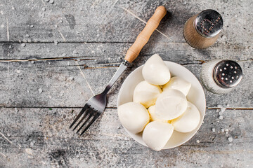 Mozzarella cheese in bowl on a table with a fork. 