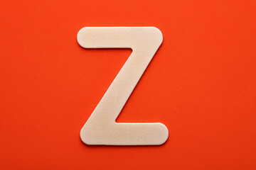 Alphabet letter Z - White wood piece on orange foamy background