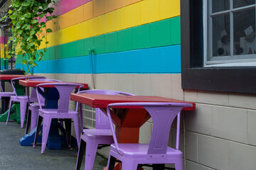 An outdoor restaurant or cafe eating area with bright yellow, green and blue stripes on the...