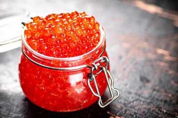 Delicious red caviar in a glass jar. 