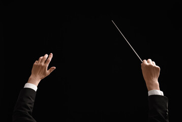 Back view of professional conductor with baton on black background, closeup