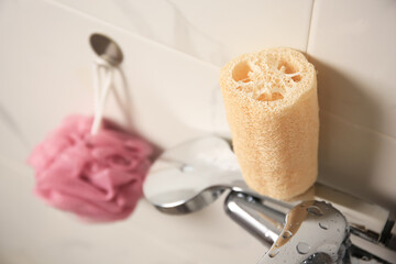 Pink shower puff and loofah sponge in bathroom, closeup