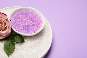 Obraz na płótnie Canvas Aromatic sea salt and beautiful flower on purple background. Space for text