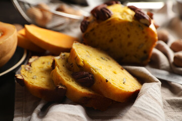 Delicious pumpkin bread with pecan nuts on tablecloth, closeup