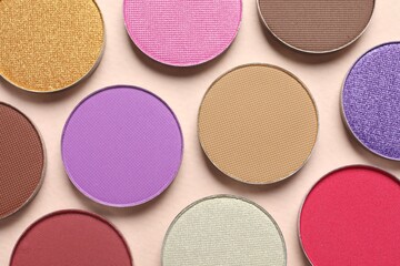 Different beautiful eye shadows on beige background, flat lay