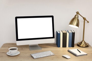 Comfortable workplace at home. Modern computer with blank screen and stationery on wooden desk. Mockup for design
