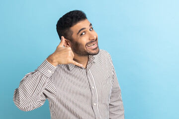 You contact us. Portrait of positive businessman with beard making gesture with fingers dial my...