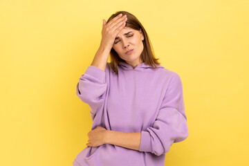 Sad woman with dark hair making facepalm gesture keeping hand on head, blaming herself for bad...