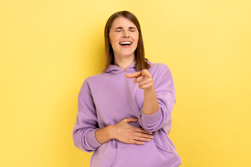 Hey, you are ridiculous. Woman laughing, holding stomach and pointing to camera, taunting you,...