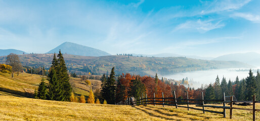 Morning fog on the slopes of the Carpathian Mountains (Yablunytsia village, Ivano-Frankivsk oblast, Ukraine). Autumn rural high-resolution panorama landscape.