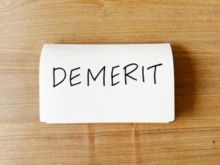 デメリット（Demerit）とペンで書かれたノート