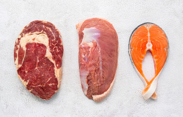Steak concept with salmon  steak, rib eye steak and duck breast set up on white concrete background. - 564099023