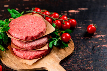 Raw burger with tomatoes and parsley. 