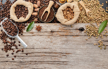 Background of various coffee , dark roasted coffee beans , ground and capsules with scoops setup on wooden background with copy space.