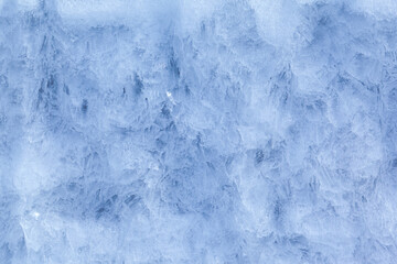 Texture of winter ice on a stone cliff. Blue natural ice background