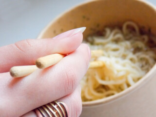 Delicious noodles with wooden sticks. Close-up
