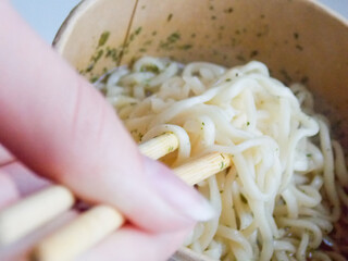 Delicious noodles with wooden sticks. Close-up