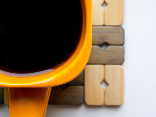 Orange coffee mug on a stand. Very close-up