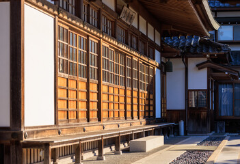 Morning sun on traditional sliding wooden doors at Japanese temple - 564100606