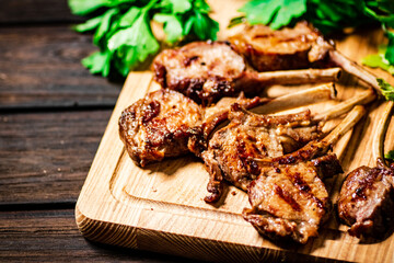 Delicious grilled lamb rack on a cutting board with parsley. 