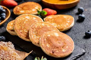 Pancakes on a stone board with fresh berries. 
