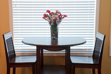 dining room table and chairs decorated with flowers in backlit interior