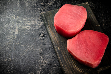 A fresh piece of raw tuna on a cutting board. 