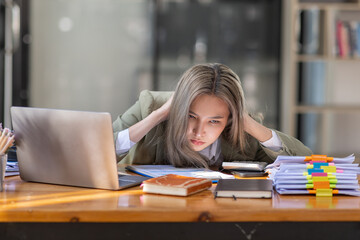 Bored Young business Asian woman sitting at her workplace at the office esk for a long time, Work mental health feel boring and Lazy, Freelance employees sleeping lying, Stress concept.