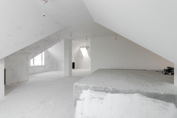 Spacious empty rooms in the attic floor after filling out the work on the wall and ceiling
