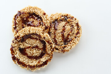 Rice crackers (intip madu or rengginang) with brown sugar on white background. Savory, sweet and crunchy.
