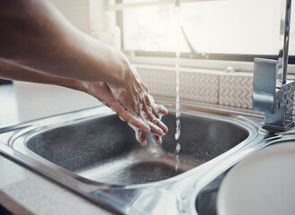 Cleaning, health or washing hands in kitchen with soap for skincare, self care or hygiene with tap water. Safety, zoom or healthy person at a sink for liquid protection against bacteria after cooking