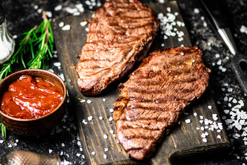 Grill steak on a wooden cutting board.