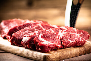 Raw beef on a cutting board with a knife. 