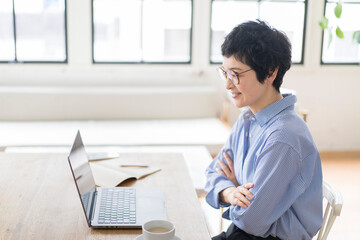 リモートでミーティングに参加する眼鏡をかけた日本人女性