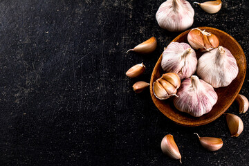 Fresh garlic on a wooden plate. 