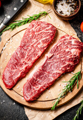 Raw steak on a wooden cutting board. 