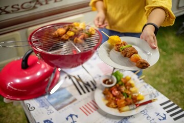 Friends making barbecue BBQ grilling over a hot fire  in the nature.Dinner party