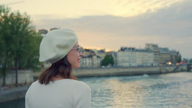 Portrait of a young woman looking at the river Seine in Paris from a bridge