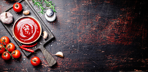Tomato sauce on a cutting board with red pepper, garlic and rosemary. 