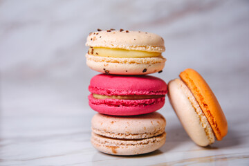 Pink, orange and beige macaroons on marble style. A beautiful and beautiful French dessert.