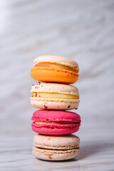 Pink, orange and beige macaroons on marble style. A beautiful and beautiful French dessert.