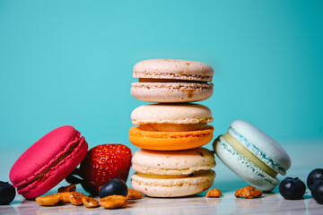 Сolorful almond cookies, pastel colors, vintage card, top view. Cake macaron or macaroon on turquoise background  fruit.
