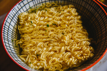 Instant pasta, Japanese and Chinese noodles. Ramen type soup in a plate with chopsticks, junk fast food. Quick-cooking pasta.