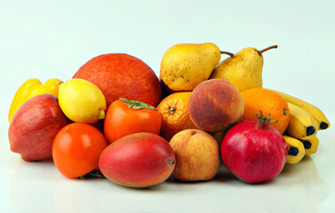 A large group of fruits of yellow, red and orange shades on a white background.  Fresh fruits.