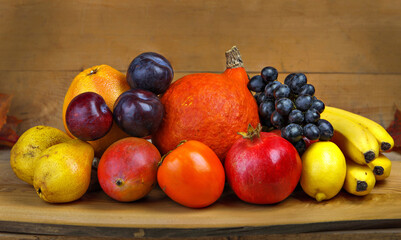 A large group of fruits of yellow, red and orange shades on a wooden table. Fresh fruits.