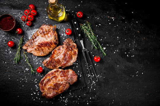 Grilled pork steak with cherry tomatoes and rosemary. 