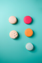 Colorful macarons. Small French cakes. Sweet and colorful french macarons on a blue background. Gift for Valentine's Day.