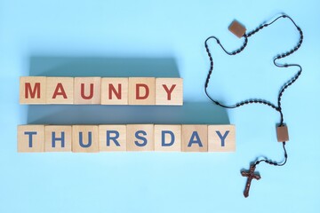Maundy Thursday holy week concept. Wooden blocks typography with rosary flat lay in blue background. - Powered by Adobe