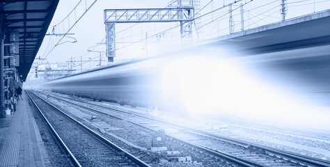 Blue high speed train runs on rail tracks - The train is going too fast as a result the air pressure is causing too much heat at the front