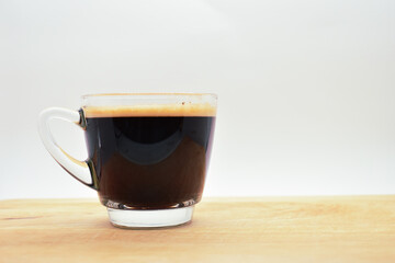 glass of hot black coffee put on wood background